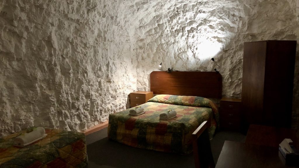 White Cliffs Underground Motel - double bedroom with soft lighting bouncing off the rock walls. www.gypsyat60.com
