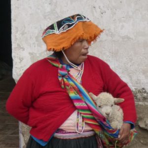 Woman from Peru carrying baby lamb in a sling. www.gypsyat60.com