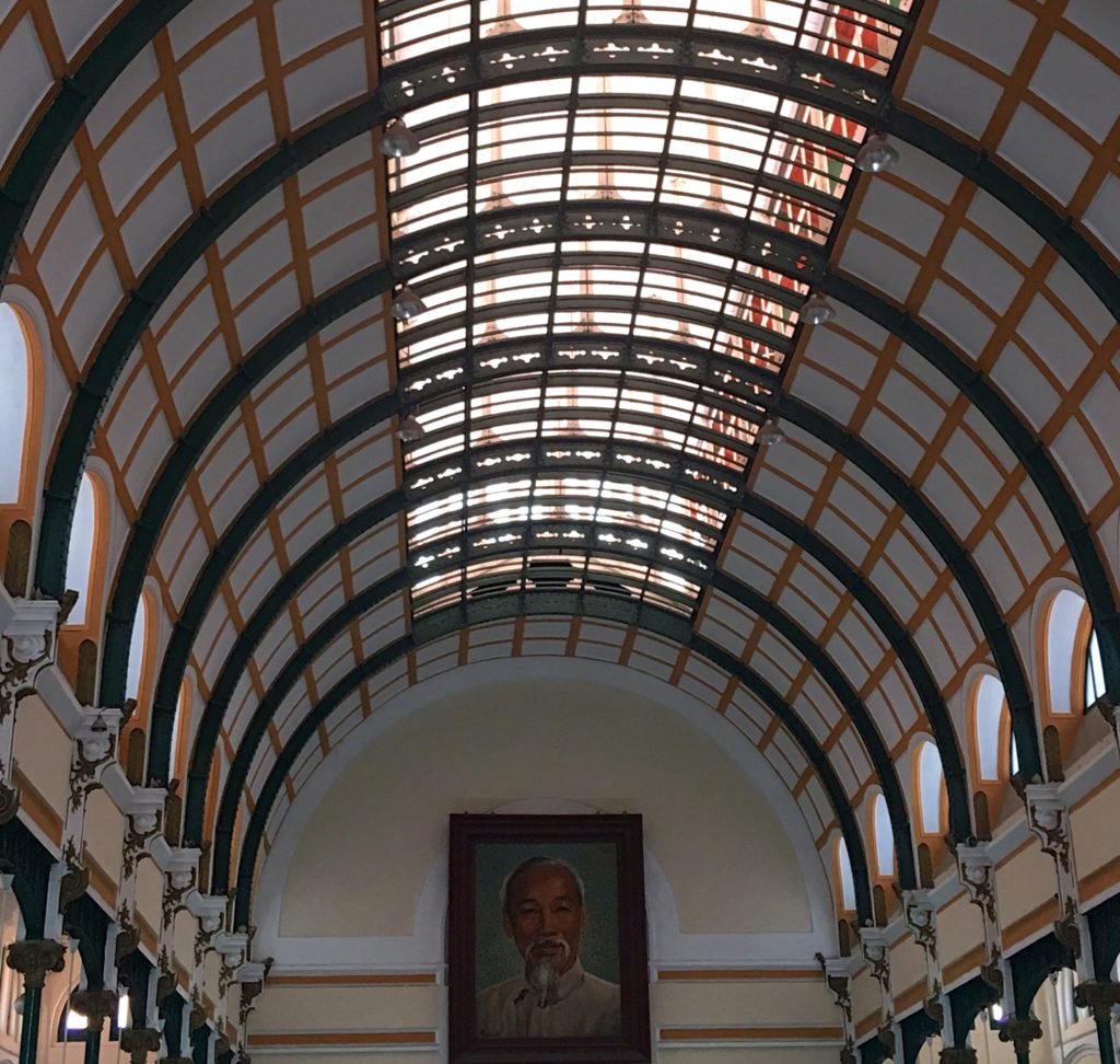 Impressive Ceiling of the Saigon Post Office with Ho Chi Minh featured on the end wall. www.gypsyat60.com