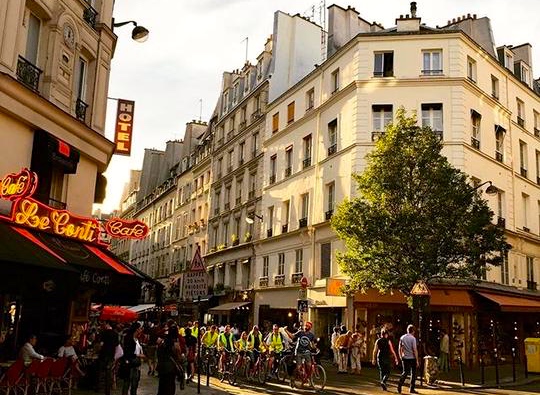 Cycling group in Paris with Hi-Vis jackets waiting at traffic lights. www.gypsyat60.com