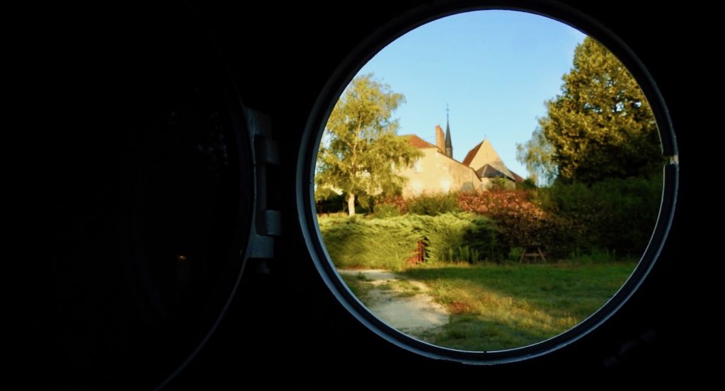 Looking out of our porthole on the Anna Maria IV to enjoy the afternoon fading light - while cycling through the Loire Valley. www.gypsyat60.com