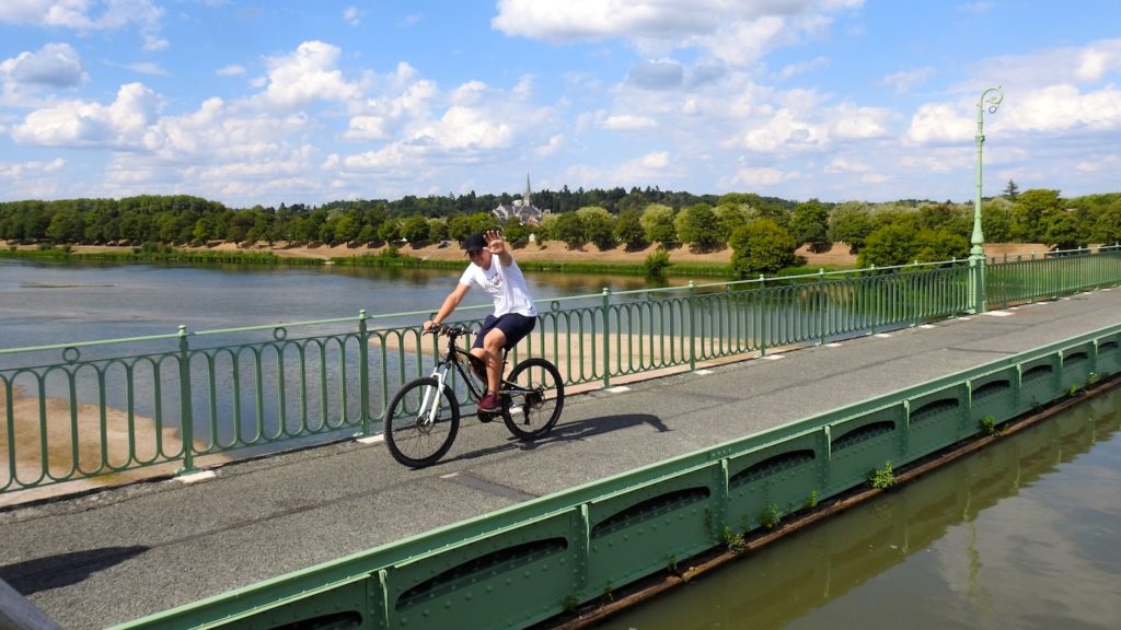 Friendly cyclist crossing the Aquaduct over the Loire River, France. www.gypsyat60.com